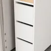 A close-up view of a white cabinet with three drawers, next to a light gray wall. Produktbild-Vorschau