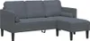 A dark gray sectional sofa with two small cylindrical pillows is shown against a white background.