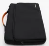 A black laptop bag with a brown handle is shown against a white background. Náhľad obrázku produktu