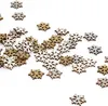 A collection of small snowflake-shaped confetti pieces scattered on a white surface. Produktbild-Vorschau