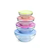 A stack of four glass bowls with colored lids. Voir les images du produit