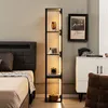 A bedroom scene featuring a tall, slim black shelf unit with integrated LED lighting, displaying decorative items. A bed is visible to the left, and a white cabinet with artwork above it is to the right. Produktbild-Vorschau