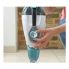A person is using a steam mop in a room with a brick wall in the background. Voir les images du produit