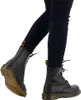 A close-up shot of a person's legs wearing black leggings and black Dr. Martens boots. Voir les images du produit