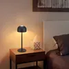 A black bedside lamp sits on a wooden nightstand next to a tissue box and a bed. Náhľad obrázku produktu