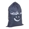 A gray laundry bag with a smiley face and the words 'wash me' printed on it. Produktbild-Vorschau