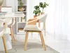 A dining room scene with a round table and chairs, a bookshelf, and plants. Produktbild-Vorschau
