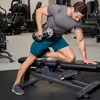 A man is performing a dumbbell row exercise in a gym. Náhled obrázku produktu