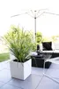 An outdoor patio setting with modern furniture and plants. Produktbild-Vorschau