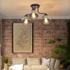A living room scene with a couch, a framed picture, and a ceiling light. Produktbild-Vorschau