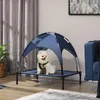 A small white dog sits on an elevated pet bed with a blue canopy in a living room. Produktbild-Vorschau
