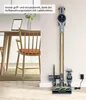 A vacuum cleaner charging station is mounted on a wall next to a dining table and chairs. Produktbild-Vorschau