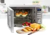 A stainless steel microwave oven with its door open, showing muffins inside. In front of the microwave are strawberries, sliced bread, and a loaf of cake on a wooden cutting board. Náhled obrázku produktu