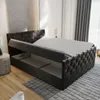 A bed with its storage compartment open, in a bedroom setting. Produktbild-Vorschau