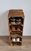 A wooden shoe rack made of stacked crates, filled with shoes, against a white wall. Produktbild-Vorschau