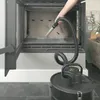 A person is using a vacuum cleaner to clean out a fireplace. Produktbild-Vorschau