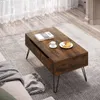 A coffee table with a book, cup, and croissant on it, placed on a rug in a living room setting. Produktbild-Vorschau