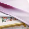 A close-up of a fabric with a gradient color effect, partially covering a framed artwork. Produktbild-Vorschau