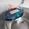A person is rinsing a robot vacuum cleaner's water tank under a faucet in a sink. Produktbild-Vorschau