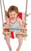 A young child is sitting in a wooden baby swing with red and white striped fabric.