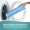 A hand is holding a blue shower mat in front of an open washing machine. Produktbild-Vorschau