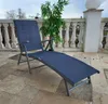A blue chaise lounge chair on a tiled patio with a railing and a plant in the background. Produktbild-Vorschau