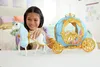A young girl is playing with a toy Cinderella carriage and horse in a bedroom. Podgląd zdjęcia produktu