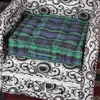 A close-up view of a plaid cushion placed on a patterned armchair. Produktbild-Vorschau