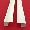 Two white PVC side rails for a roller blind are laid diagonally on a red background. Produktbild-Vorschau