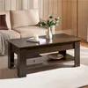 A dark brown wooden coffee table with a shelf is placed in a living room setting in front of a beige sofa. Produktbild-Vorschau