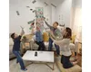 A family is playing a game where money is being thrown in the air. Produktbild-Vorschau