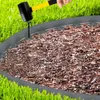 A person is using a mallet to hammer a stake into the ground to secure a flexible plastic lawn edging. Náhled obrázku produktu