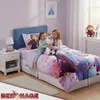 Two young girls are sitting on a bed with Frozen-themed bedding, holding a stuffed Olaf. Produktbild-Vorschau