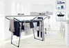 A drying rack with clothes on it, set in a room with a painting on the wall. Produktbild-Vorschau