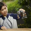 A young boy holds a robot toy in a natural, outdoor setting. Anteprima dell’immagine prodotto
