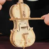 A close-up of a wooden model cello being held by hands. Anteprima dell’immagine prodotto