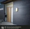 An outdoor wall lamp is mounted on a dark gray, horizontally-paneled wall next to a wooden door, with rain falling. Anteprima dell’immagine prodotto