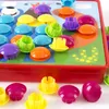 A close-up view of a colorful button mosaic toy with various colored buttons arranged on a board with a volcano and landscape design. Produktbild-Vorschau