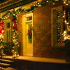 A brick house decorated with Christmas lights and garlands. Produktbild-Vorschau