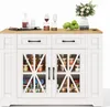 A white kitchen island with a wooden countertop, featuring glass cabinet doors revealing stored items, drawers, and decorative elements like wine glasses and a vase of flowers. Náhled obrázku produktu