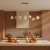 A kitchen island with fall decorations, including pumpkins and autumn leaves, in front of a kitchen counter with cabinets and a range hood. Náhľad obrázku produktu