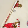 A close-up view of a cream-colored fabric with cartoon illustrations of bears playing soccer. Produktbild-Vorschau