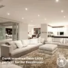 A modern living room with a large sectional sofa and ottoman, illuminated by recessed ceiling lights. Voir les images du produit