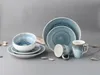 A set of blue and white stoneware dishes and mugs arranged on a gray background with small stones. Náhľad obrázku produktu