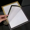 A hand is holding and lifting the corner of a magnetic photo frame, revealing another frame underneath. Anteprima dell’immagine prodotto