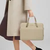 A person holding a beige laptop bag. Náhľad obrázku produktu