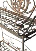 A close-up view of an ornate metal shelf with intricate scrollwork and a floral design. Anteprima dell’immagine prodotto