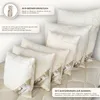 Several pillows of varying sizes are arranged on top of a quilted blanket. Produktbild-Vorschau