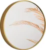 A round mirror with a gold frame, reflecting dried palm fronds. Náhled obrázku produktu
