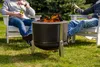 Two people sitting in chairs around a fire pit in a backyard. Produktbild-Vorschau
